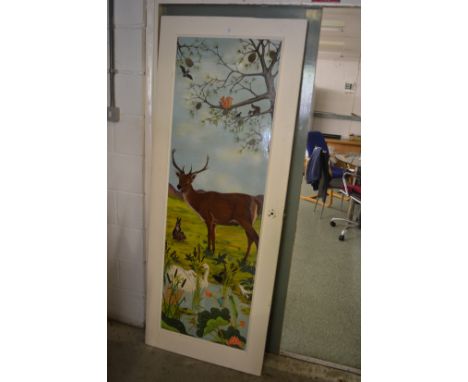 An unusual painted door decorated with a woodland scene.