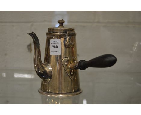 A silver coffee pot with turned wood handle.