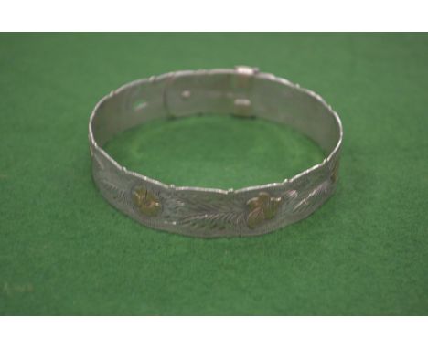 An engraved silver bangle.