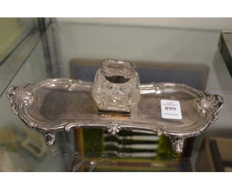 A silver desk stand with inkwell.