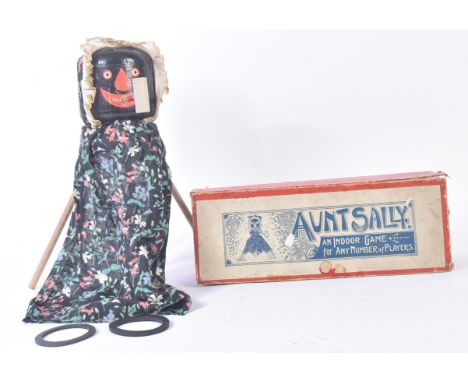 An early 20th Century ' Aunt Sally ' parlour game. Wooden doll with tripod legs, wooden pipe and rubber hoops for throwing. M