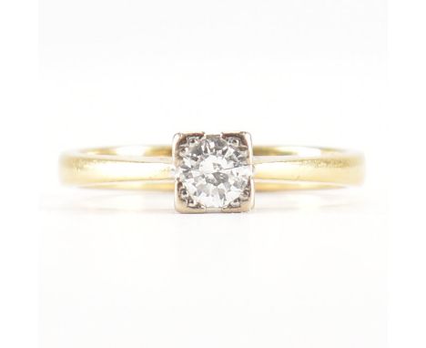 A hallmarked 18ct gold and diamond solitaire ring. The ring being set with a round brilliant cut diamond within a square sett