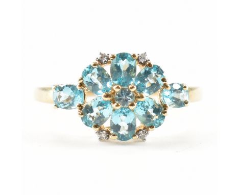 A hallmarked 9ct gold and blue stone cluster ring. The ring being set with a flower head of oval cut blue topaz stones with f