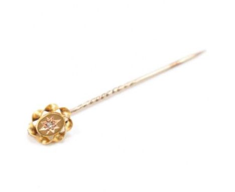 A vintage 15ct gold &amp; diamond stick pin. The pin having a central round old cut star set diamond surrounded by a twisted 