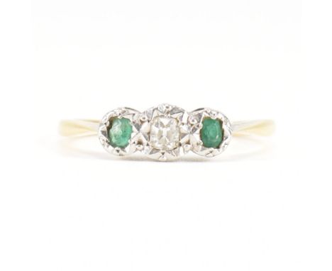 An 18ct yellow gold, platinum, diamond &amp; emerald three stone ring. The ring having a central oval cut illusion set diamon