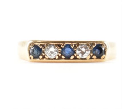 A hallmarked 9ct yellow gold, sapphire &amp; diamond ring. The ring having three round cut sapphires spaced by two round cut 