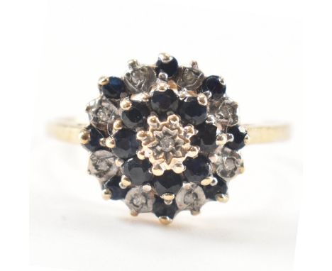 A hallmarked 9ct yellow gold, diamond &amp; sapphire cluster ring. The ring having a central star set diamond surrounded by a