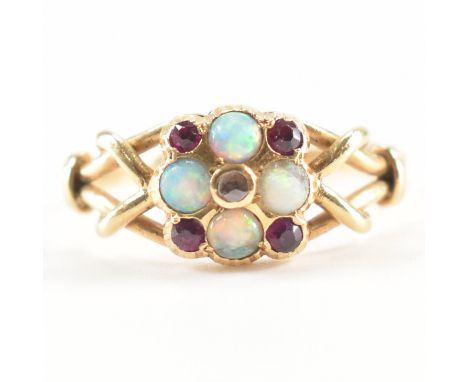 A 19th Century Victorian yellow gold, opal, diamond and ruby ring cluster ring. The central round cut diamond within a halo o