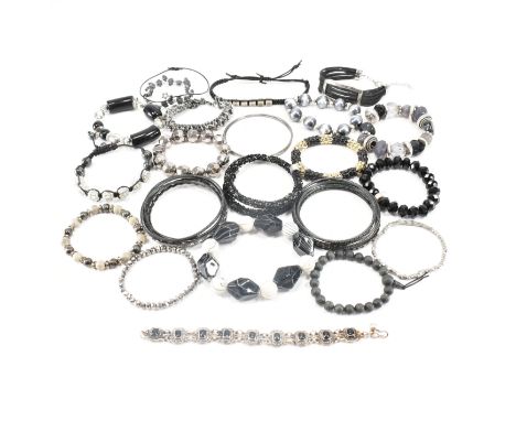 An assorted collection of black tone bangles &amp; bracelets. The lot to include; silver tone metal, white stones, beads, etc