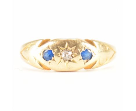 A hallmarked 18ct gold diamond and blue stone gypsy ring. The ring being star set with a round cut diamond to the centre flan