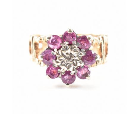 A hallmarked 9ct gold ruby and diamond cluster ring. The ring being set with a central illusion set diamond surrounded by rou