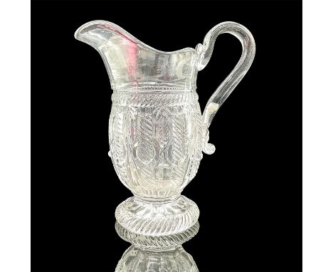 Clear glass handled pitcher decorated with a spiral designed on body and round base. Dimensions: 5.5"L x 3.25"W x 7"HProvenan