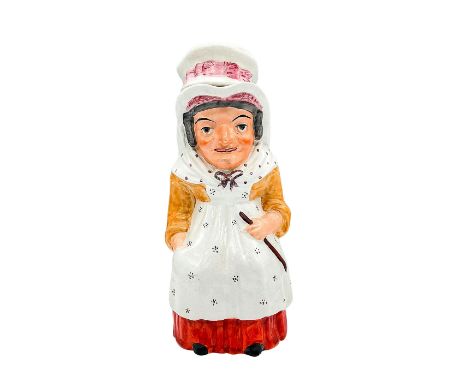 A hand painted earthenware figural covered jug of Judy from 'Punch and Judy'. Dressed in a yellow blouse, red skirt, and a wh