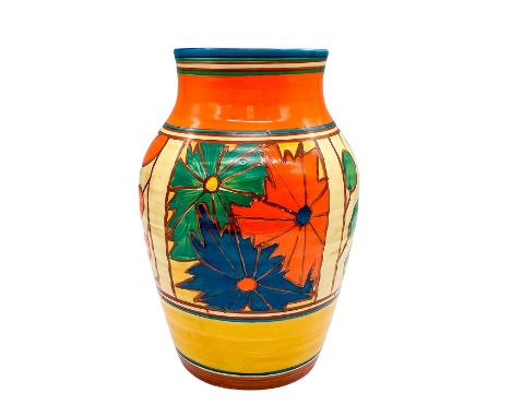 A beautiful hand painted Art Deco ceramic vase decorated in an abstract geometric flowers in a colorful palette. Clarice Clif