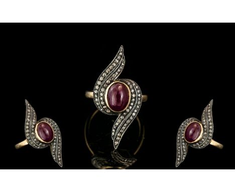 Antique Style Dress Ring, set with a central cabochon Ruby, surrounded by rose cut diamonds, and a later silver band.  Ring s