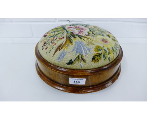 A Victorian mahogany footstool with padded upholstered tapestry top, raised on bun feet, 