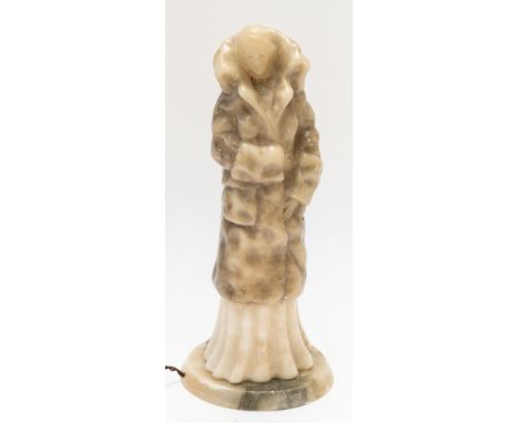 AN ART DECO ALABASTER FIGURAL TABLE LAMPModelled as lady in dress with a high collared coat, 44.5cm highNB: The base is loose