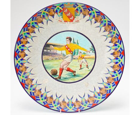 PAUL MIGNON FOR LONGWY, FRANCE: A LARGE FAIENCE CHARGERDecorated in the centre with a panel of two footballers beneath the ar