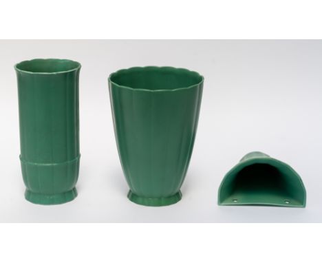 KEITH MURRAY FOR WEDGWOOD: TWO MATT GREEN GLAZED VASES AND A WALL POCKET (3)Each vase moulded with flutes, the taller vase of