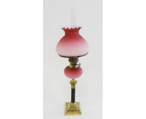 A VICTORIAN BRASS COLUMNAR OIL LAMP WITH SPIRALLY REEDED PINK SATIN GLASS FOUNT, BRASS BURNER AND MATCHING GLASS SHADE, 47CM 