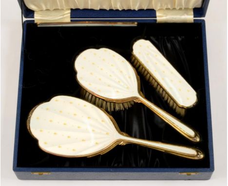 AN ELIZABETH II FOUR PIECE SILVER GILT AND CREAM GUILLOCHE ENAMEL BRUSH SET, BIRMINGHAM 1960/61, CASED, GOOD CONDITION, INCLU