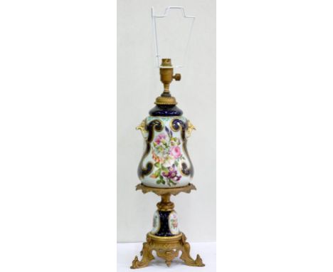 A GILTMETAL MOUNTED CONTINENTAL PORCELAIN OIL LAMP, PAINTED WITH FLOWERS IN COBALT AND GILT BORDERS, 46CM H EXCLUDING LATER E