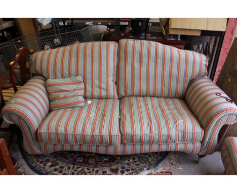 A contemporary four piece suite, comprising a two seater settee, a pair of armchairs and a matching pouffe, all in floral str