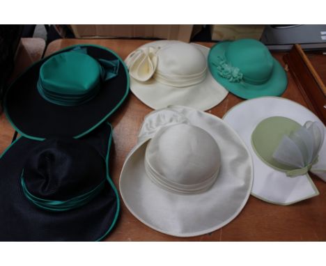A navy hat with jade trim, a black with jade trim hat (early 1980s), a turquoise green hat, an apple green with fan detail on
