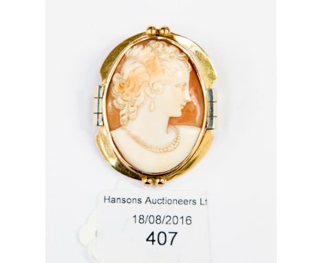 A cameo brooch, depicting bust portrait of a lady in necklace and earrings, mount stamped 18 ct 