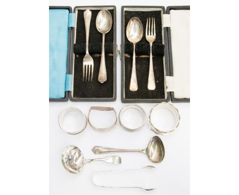 Two cased sets of silver dessert spoons and fork, silver caddy spoons, nips, child's feeder spoon, four silver napkin rings, 