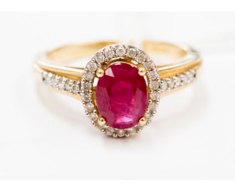 A ruby and diamond oval cluster 18 ct gold ring with diamond set shoulders