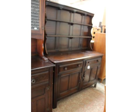 An Ercol elm dresser with rack, the rack with two shelves, the base section with two drawers over two doors, together with a 