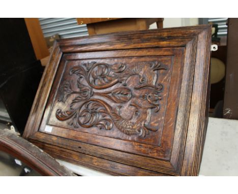 An early 20th Century oak wall hanging corner cupboard, the door with a symmetrically carved panel depicting scrolled foliage