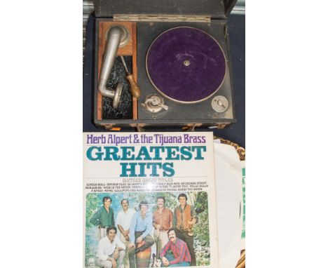 A portable record player, with approx. fifteen vinyl records, a mantle clock, a round wall mirror, and a suit case 