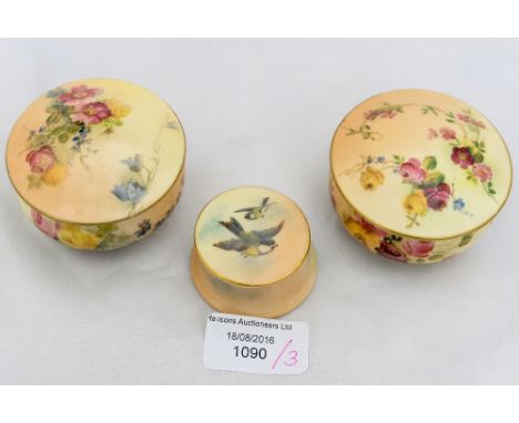 A pair of Royal Worcester blush ivory pots and covers painted with flowers and a Royal Worcester pill box and cover painted w