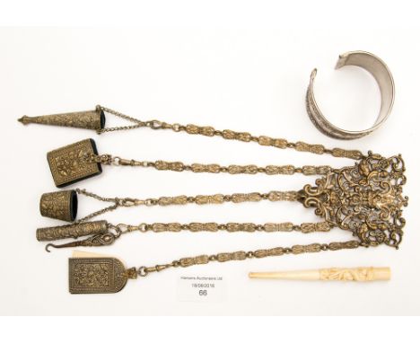 A Victorian chatelaine hook with fobs, white metal, mask cherub and fruit decoration, together with white metal torque bangle