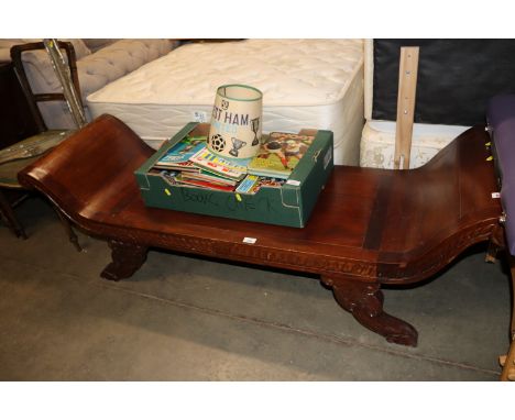 A carved wooden scroll end bench