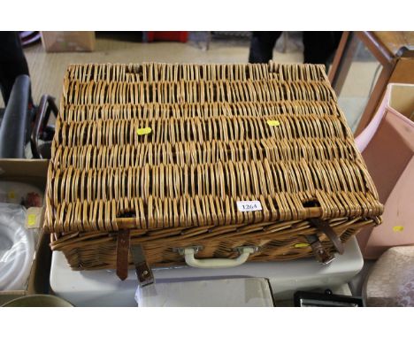 An Ideal Standard sink with a wicker picnic basket and contents