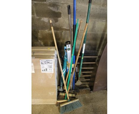 A bundle of long handled garden tools to include brooms, rake, spirit level etc