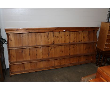 A large stripped pine wall shelf