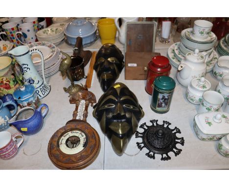 An oak mounted barometer AF, two carved wooden and brass decorated face masks, picture frame, flat iron