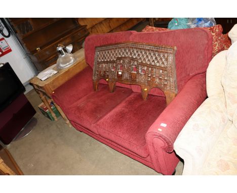 A red upholstered two seater sofa 