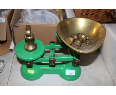 A green painted set of scales with brass and other weights