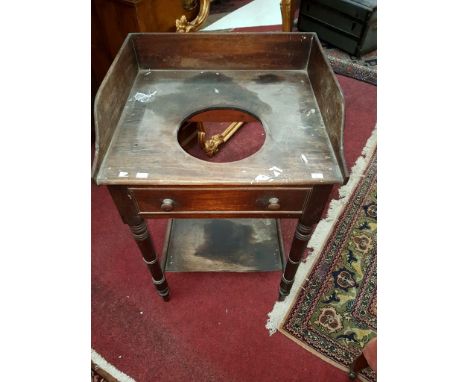 A WILLIAM IV PERIOD MAHOGANY WASH STAND, with three-quarter gallery and central bowl aperture, above a mock frieze drawer, ra