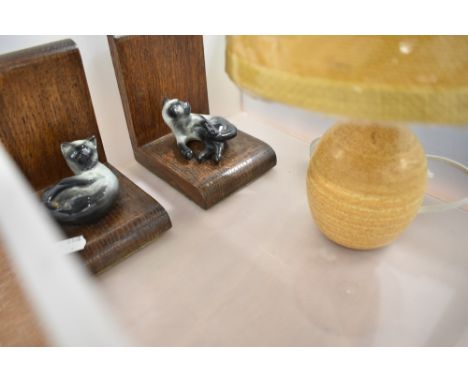 A modern Cumbrian studio pottery table lamp with mustard coloured shade, together with a pair of oak and ceramic cat form boo