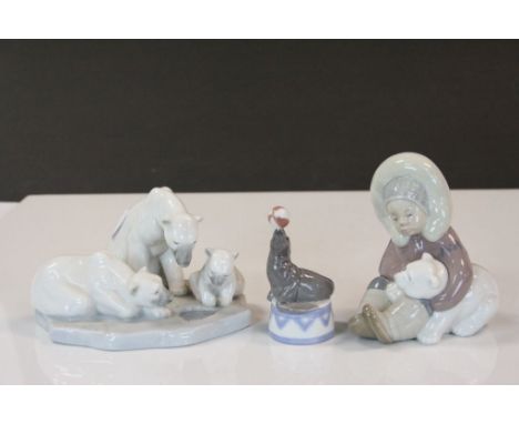 Three vintage Lladro ceramic sculptures to include a Polar bear trio, Inuit child with Polar Bear cub and a Sea Lion balancin