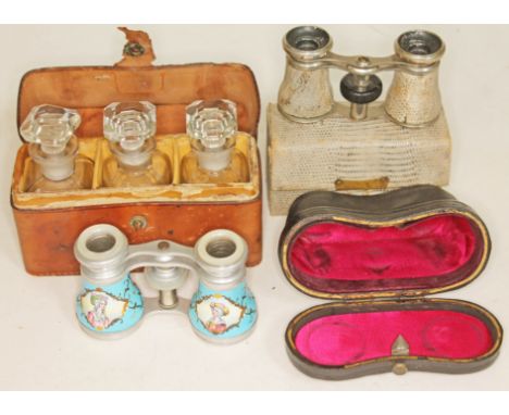 A pair of enamel opera glasses with mother of pearl eye rings, a cased set of three vintage bottles and a pair of snake skin 