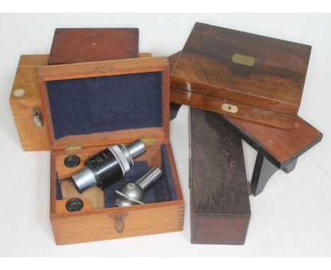 Two microscope lenses together with various empty instrument boxes.  