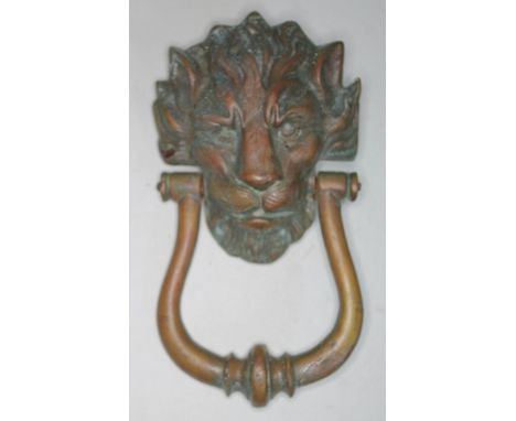 An antique cast brass door knocker formed as a lion's head, length 24cm.  