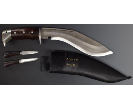 Large Kukri in scabbard and two smaller examples&nbsp;